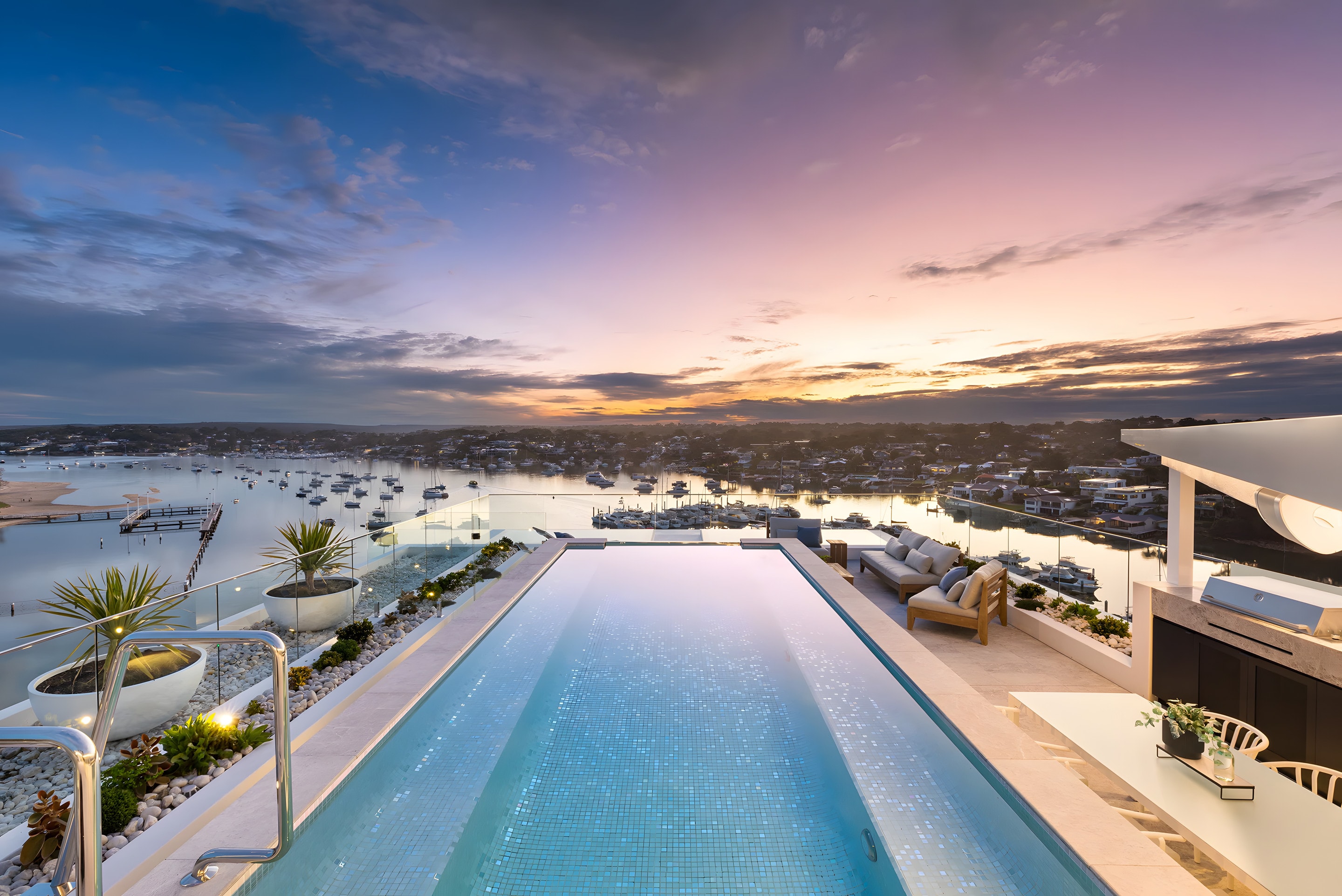 A rooftop pool looking over the bay at sunset