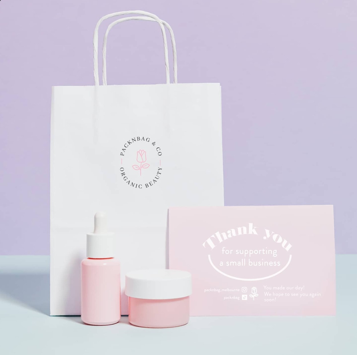 A branded paper bag with skincare and a thank-you card