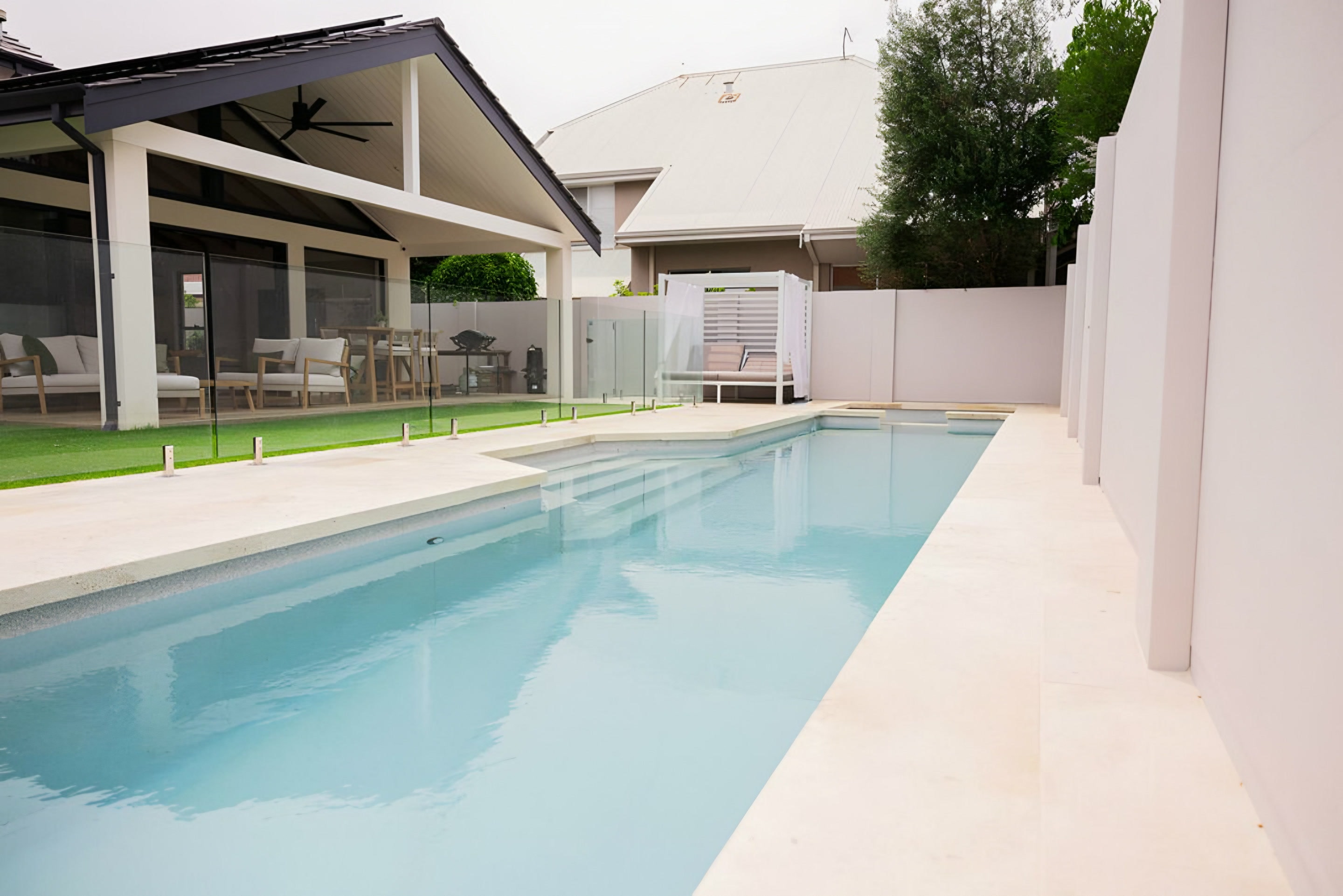 A lap pool beside white rendered walls