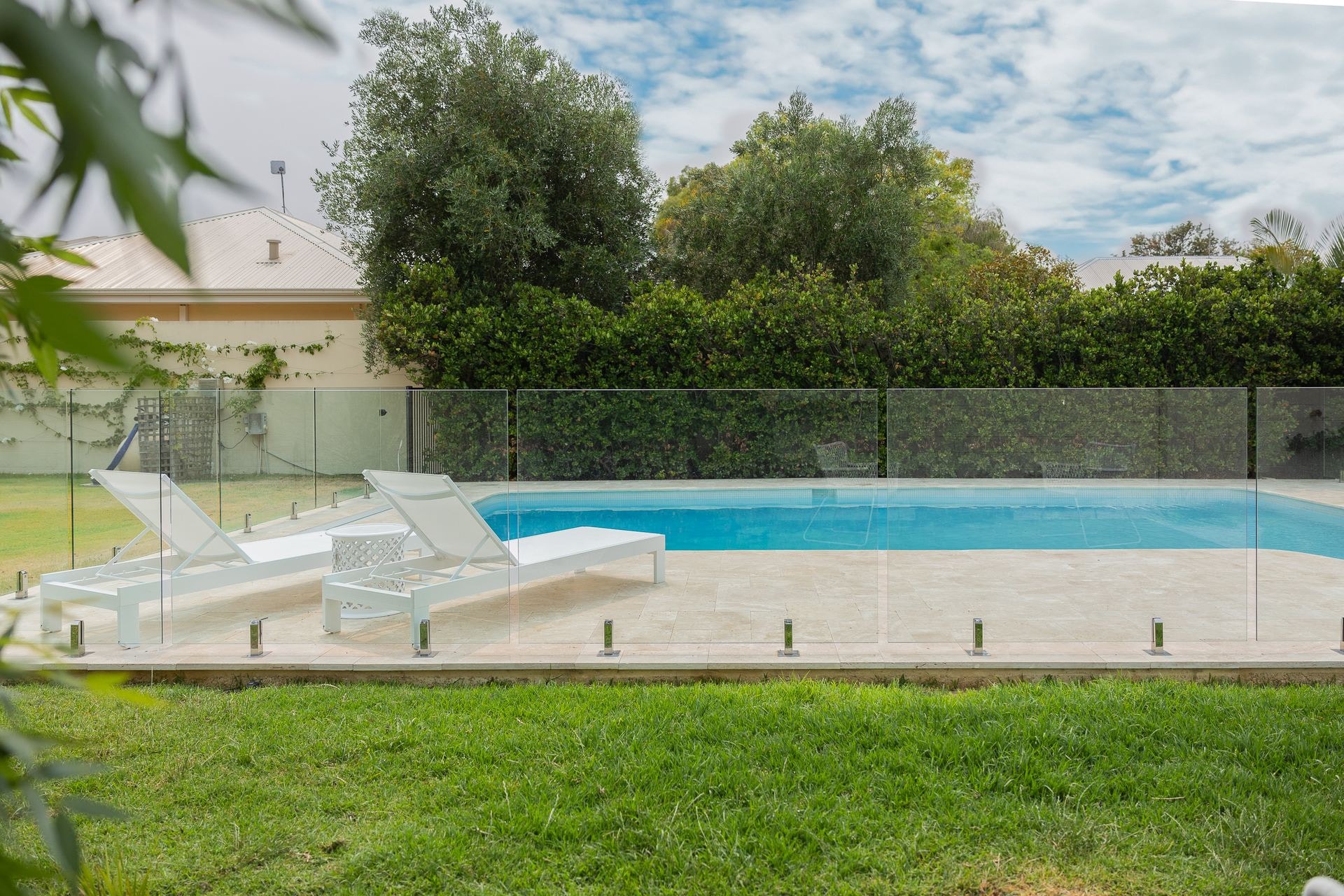 White sun loungers reflected in a pool