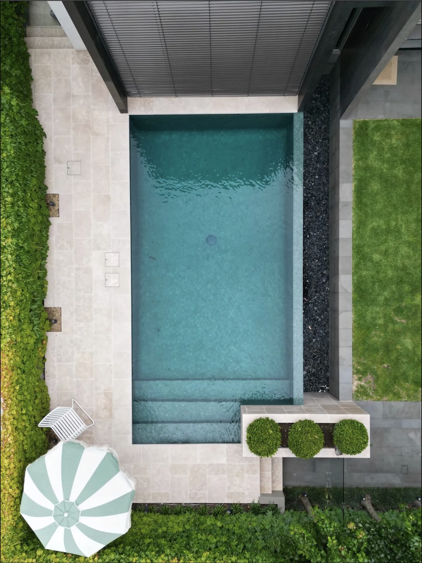 A narrow lap pool between garden beds