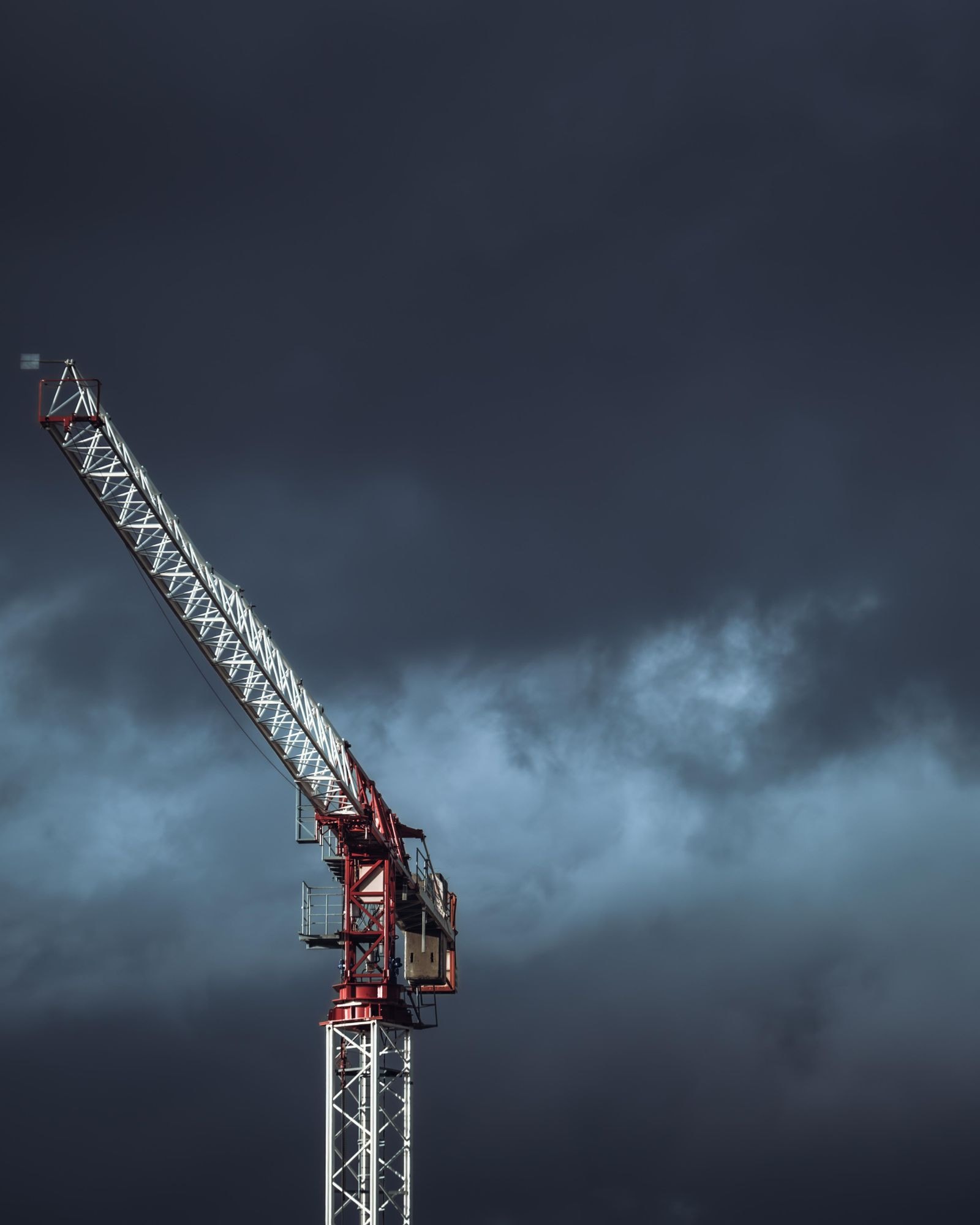 A tower crane against a storm sky