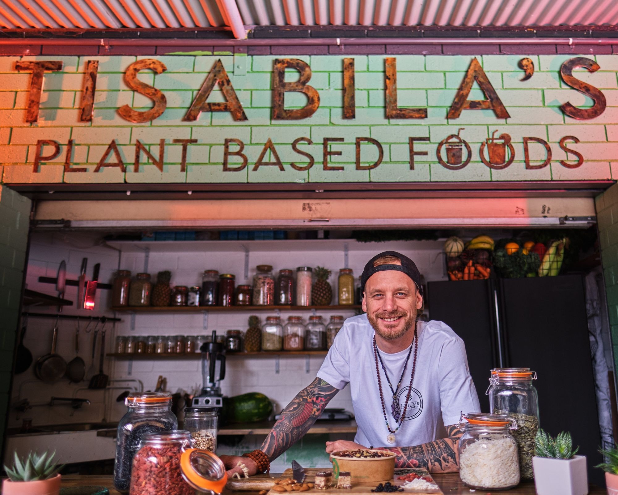 A café owner behind the counter of a plant-based kitchen