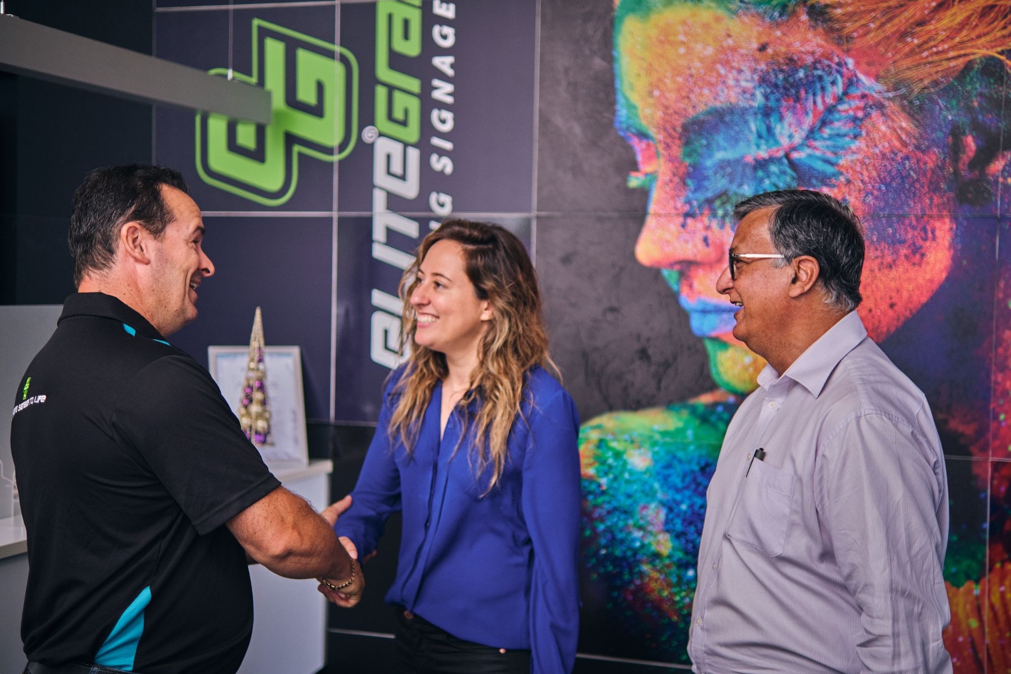A handshake in a signage company’s showroom