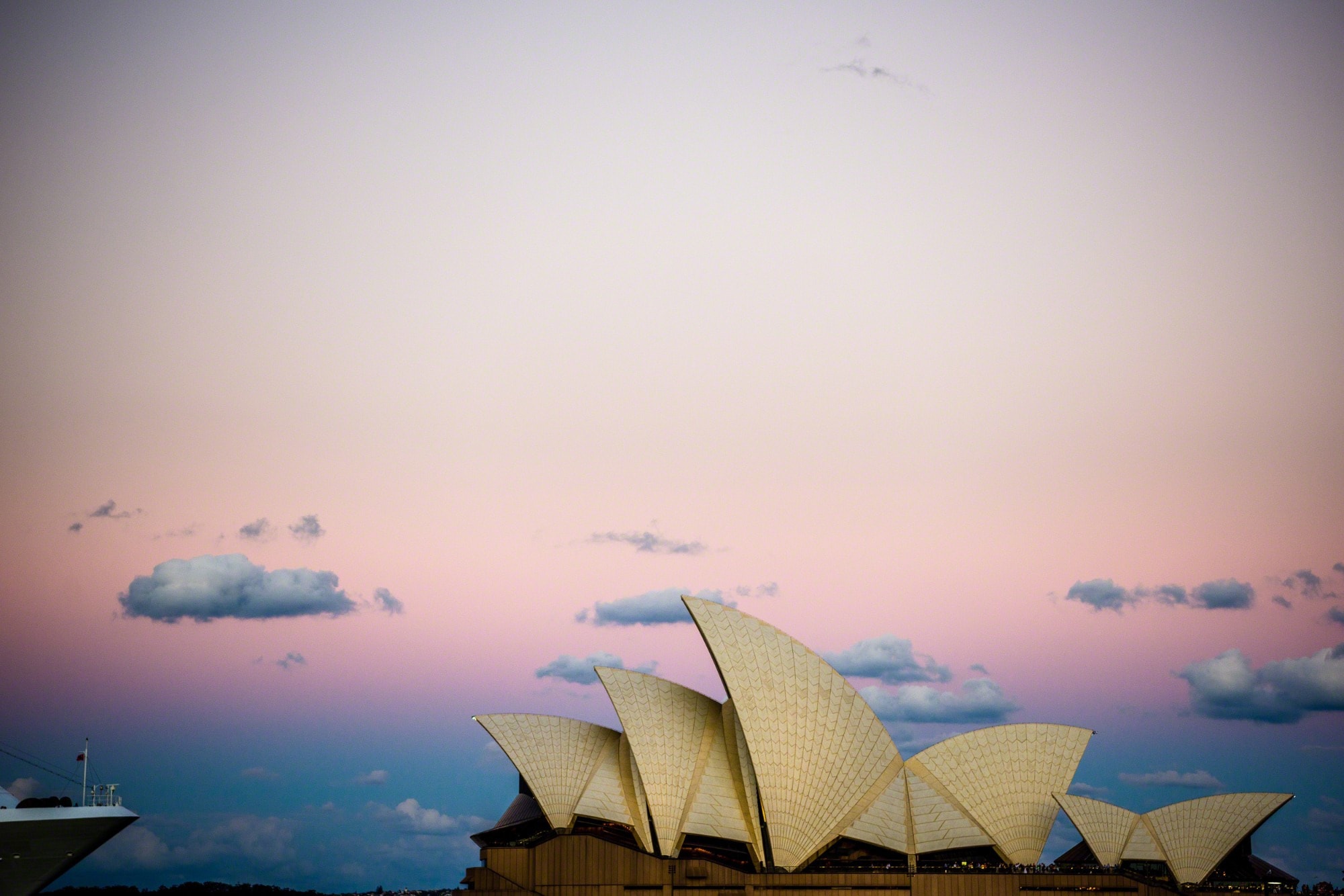 The Sydney Opera House sails against a pink dusk sky