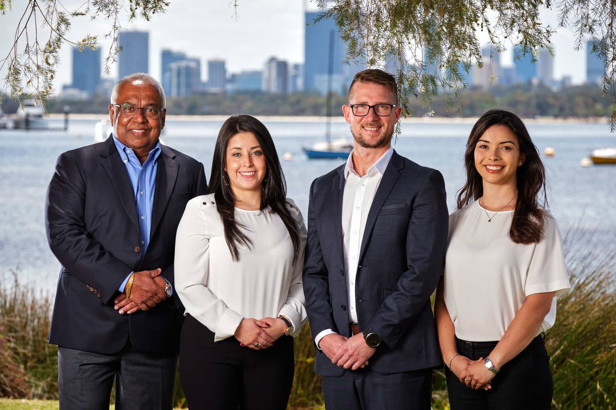 A team portrait by the river with the city behind