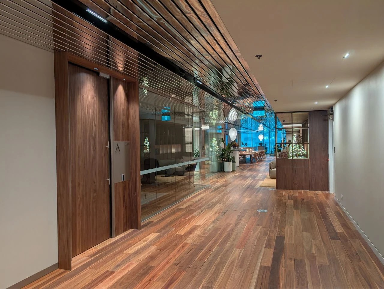 A glazed meeting room along a timber corridor